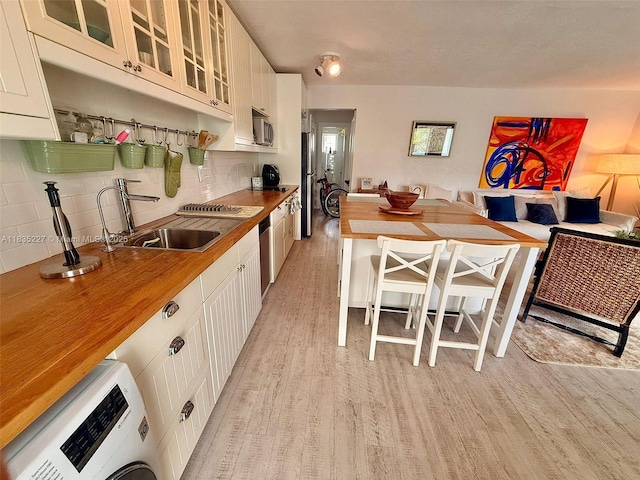 224 Meridian Ave Unit 10, Miami Beach, FL 33139 - kitchen with light wood-style floors, stainless steel appliances, wooden counters, and washer / clothes dryer