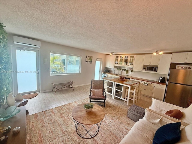 224 Meridian Ave Unit 10, Miami Beach, FL 33139 - living area featuring an AC wall unit, light wood-style floors, and a textured ceiling