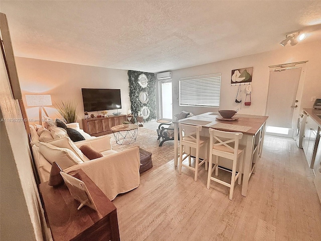 224 Meridian Ave Unit 10, Miami Beach, FL 33139 - living area featuring a textured ceiling, an AC wall unit, and light wood-style floors