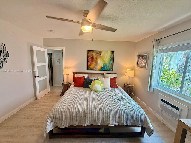 224 Meridian Ave Unit 10, Miami Beach, FL 33139 - bedroom featuring light wood-type flooring, a textured ceiling, ceiling fan, and a wall mounted air conditioner