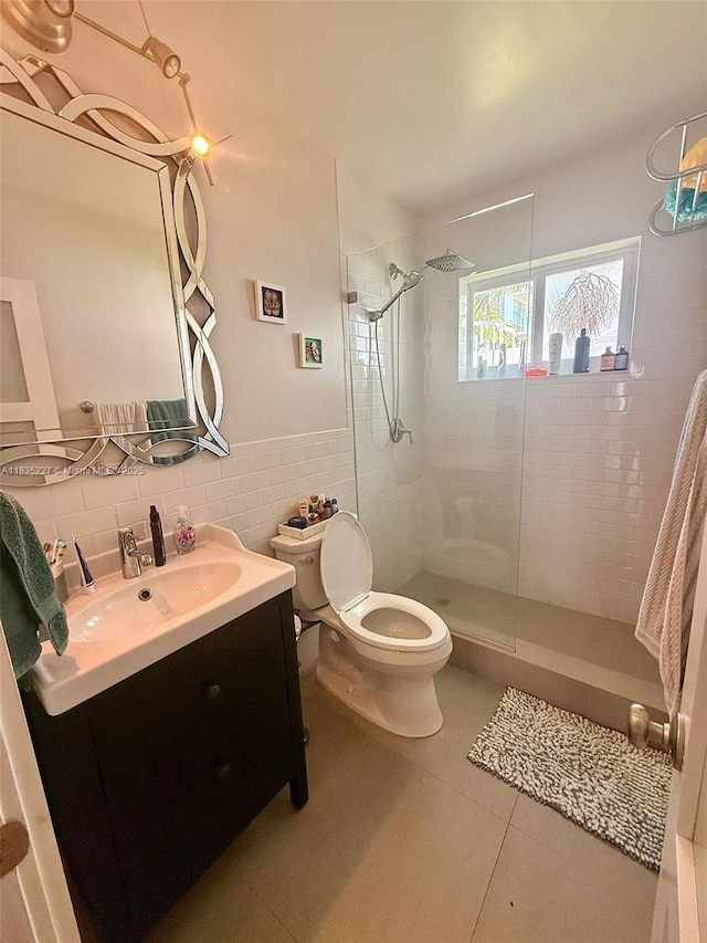 224 Meridian Ave Unit 10, Miami Beach, FL 33139 - bathroom featuring walk in shower, vanity, tile walls, tile patterned floors, and a wainscoted wall
