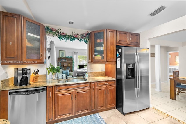 5001 SW 11th Cir, Margate, FL 33068 - kitchen featuring stainless steel appliances, brown cabinetry, light tile patterned floors, and glass insert cabinets