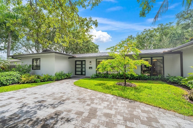 15121 SW 69th Ct, Palmetto Bay, FL 33158 - mid-century inspired home with a standing seam roof, stucco siding, a metal roof, and a front lawn