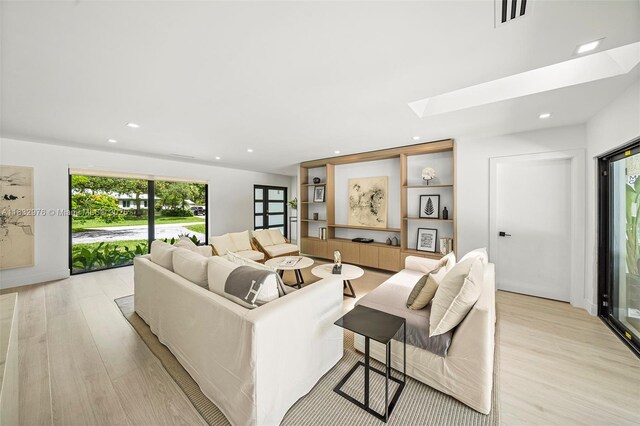 15121 SW 69th Ct, Palmetto Bay, FL 33158 - living room with light wood finished floors, a skylight, and recessed lighting
