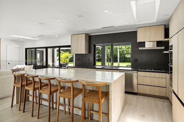 15121 SW 69th Ct, Palmetto Bay, FL 33158 - kitchen with stainless steel appliances, light brown cabinets, modern cabinets, a kitchen breakfast bar, and wall chimney exhaust hood