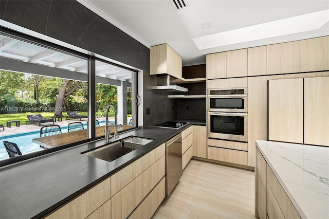 15121 SW 69th Ct, Palmetto Bay, FL 33158 - kitchen with light brown cabinetry, stainless steel appliances, dark stone countertops, and light wood-type flooring