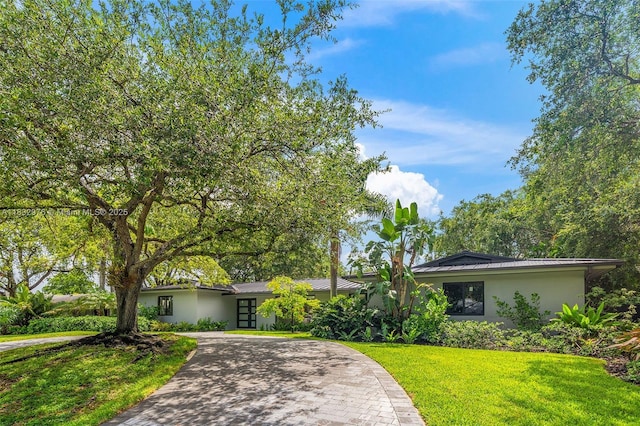 15121 SW 69th Ct, Palmetto Bay, FL 33158 - mid-century home with stucco siding, decorative driveway, a front yard, and a metal roof