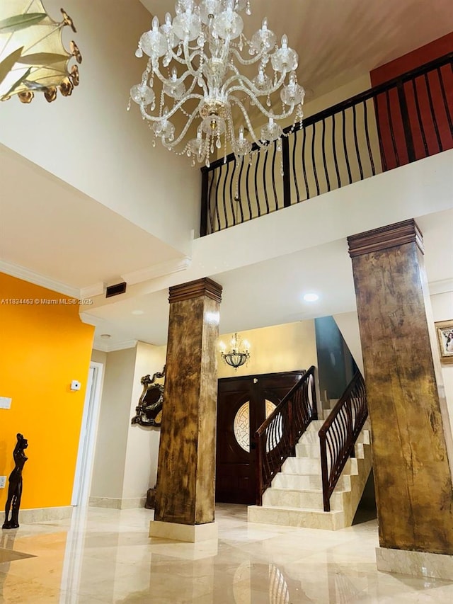 8565 NW 168th Ter, Miami Lakes, FL 33016 - stairway with a chandelier, a towering ceiling, decorative columns, ornamental molding, and marble tiled floors