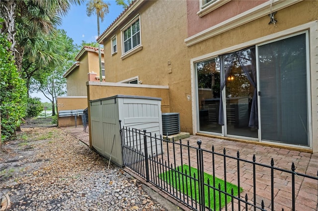604 SW 107th Ave Unit 706, Pembroke Pines, FL 33025 - rear view of house featuring stucco siding, a patio area, and a storage shed