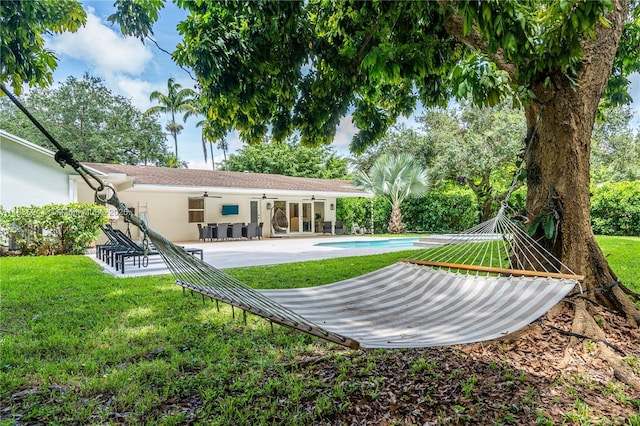 10821 SW 92nd Ave, Miami, FL 33176 - back of property with a ceiling fan, a patio, a lawn, an outdoor pool, and stucco siding