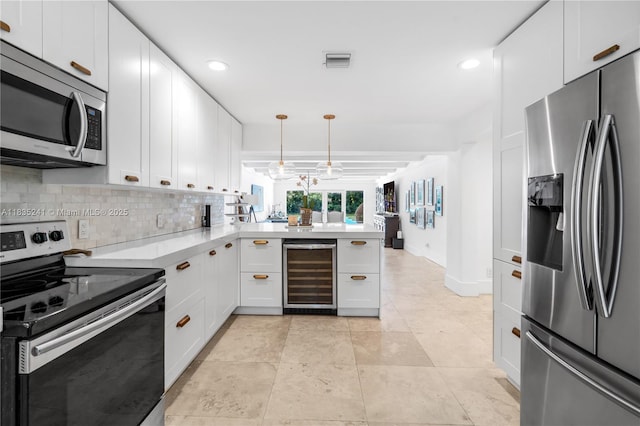 10821 SW 92nd Ave, Miami, FL 33176 - kitchen featuring appliances with stainless steel finishes, beverage cooler, a peninsula, light countertops, and tasteful backsplash