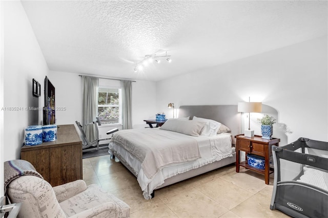 10821 SW 92nd Ave, Miami, FL 33176 - bedroom with light tile patterned flooring, a textured ceiling, and track lighting
