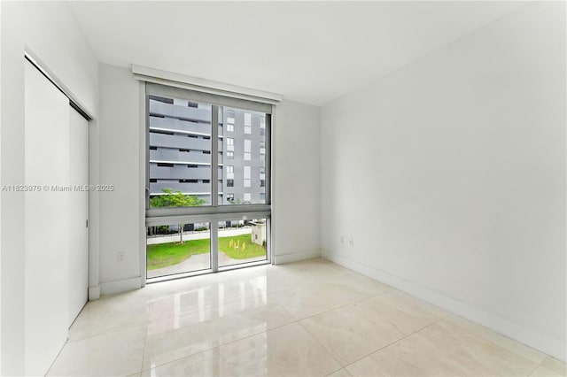 16385 Biscayne Blvd Unit 301, North Miami Beach, FL 33160 - tiled empty room featuring baseboards