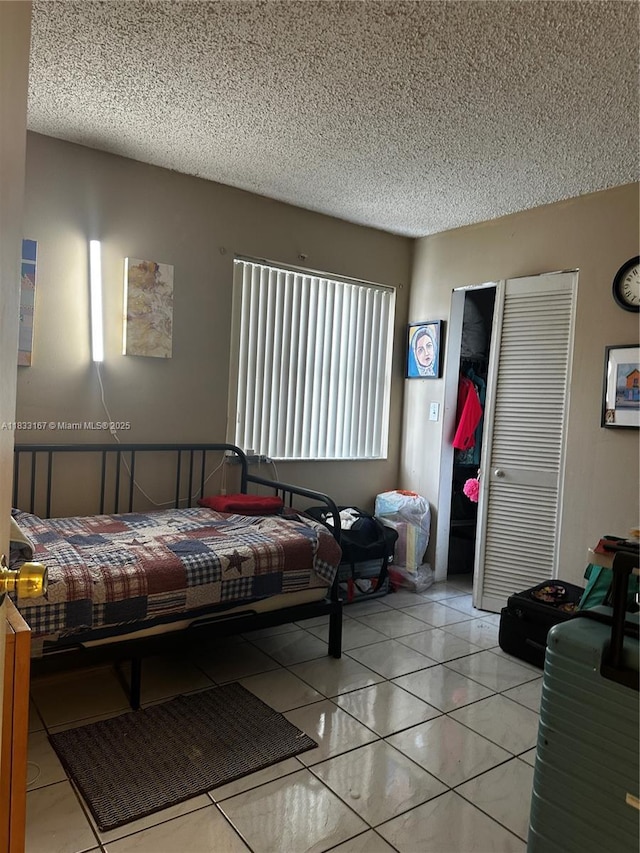 311 W Park Dr Unit 101-13, Miami, FL 33172 - bedroom featuring a textured ceiling, a closet, and tile patterned flooring