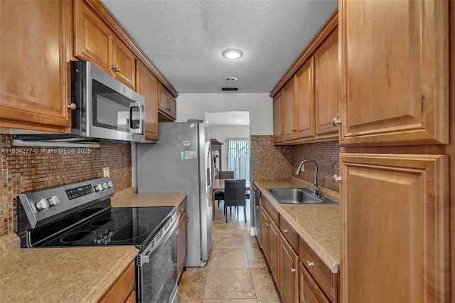 8256 NW 9th Ct Unit 2, Plantation, FL 33324 - kitchen featuring stainless steel appliances, tasteful backsplash, brown cabinets, light countertops, and a textured ceiling