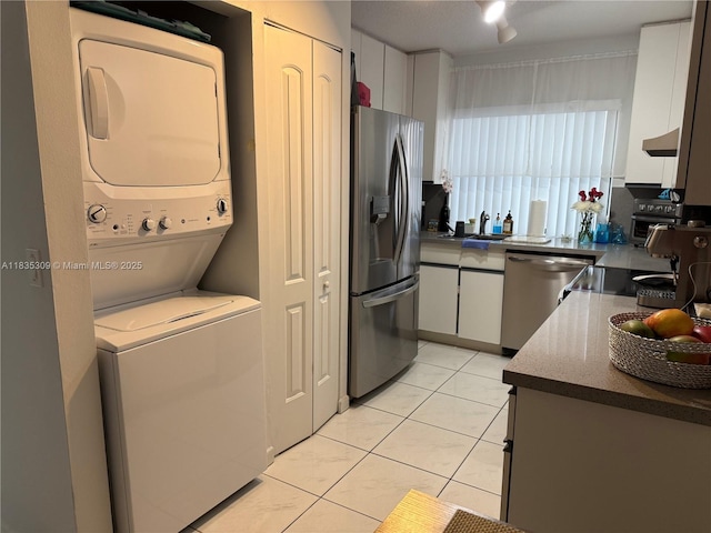 17048 NW 66th Ct, Miami Lakes, FL 33015 - kitchen featuring appliances with stainless steel finishes, estacked washer and dryer, white cabinetry, light tile patterned floors, and extractor fan
