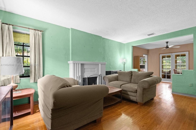 2025 SW 19th St, Miami, FL 33145 - living room with wood finished floors, a ceiling fan, a textured ceiling, and a fireplace