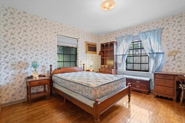 2025 SW 19th St, Miami, FL 33145 - bedroom with wallpapered walls, light wood-type flooring, and a wall mounted air conditioner