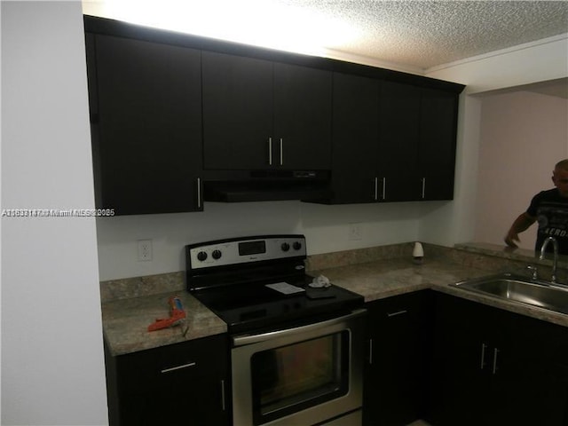 95 NE 41st St Unit O230, Oakland Park, FL 33334 - kitchen with electric range, exhaust hood, dark cabinetry, a textured ceiling, and light countertops