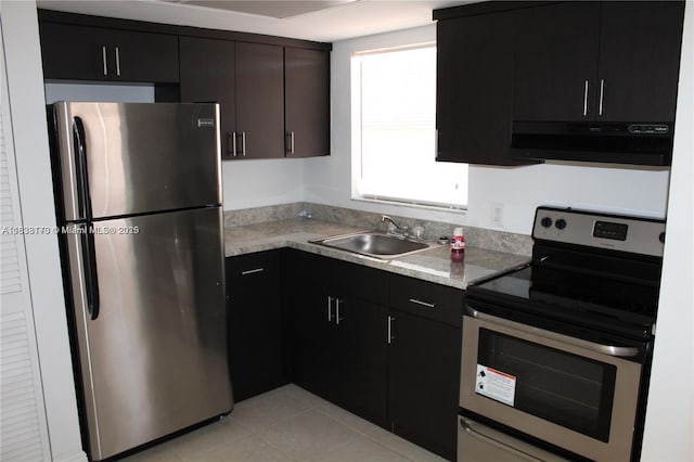 101 NE 41st St Unit F107, Oakland Park, FL 33334 - kitchen with stainless steel appliances, exhaust hood, light countertops, light tile patterned floors, and dark cabinetry