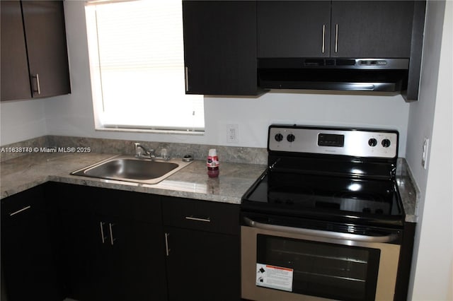 101 NE 41st St Unit F107, Oakland Park, FL 33334 - kitchen with stainless steel electric range, exhaust hood, dark cabinets, and light countertops