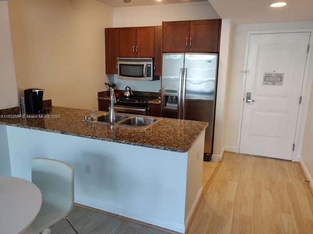 400 N Federal Hwy Unit 305S, Boynton Beach, FL 33435 - kitchen featuring stainless steel appliances, a peninsula, dark stone countertops, light wood-type flooring, and recessed lighting