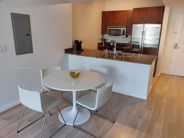 400 N Federal Hwy Unit 305S, Boynton Beach, FL 33435 - kitchen featuring electric panel, stainless steel appliances, light wood-style flooring, and a peninsula