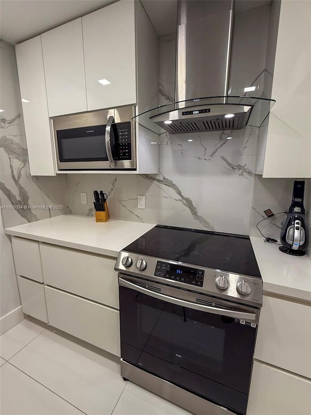 20379 W Country Club Dr Unit 1434, Aventura, FL 33180 - kitchen with appliances with stainless steel finishes, wall chimney range hood, light countertops, and decorative backsplash