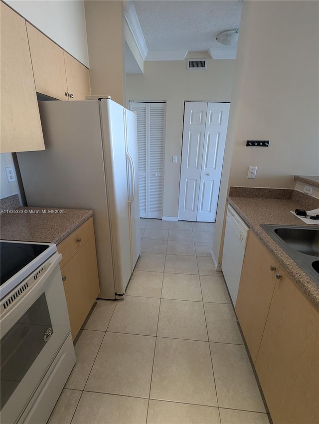 616 Clearwater Park Rd Unit 703, West Palm Beach, FL 33401 - kitchen with white appliances, light tile patterned floors, dark countertops, ornamental molding, and a textured ceiling