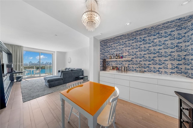 1100 W Ave Unit 1614, Miami Beach, FL 33139 - dining space with light wood-type flooring, a chandelier, and a water view