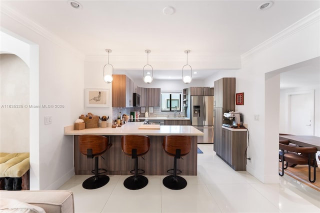 2485 SW 19th Ter, Miami, FL 33145 - kitchen with appliances with stainless steel finishes, a peninsula, a breakfast bar area, light countertops, and crown molding