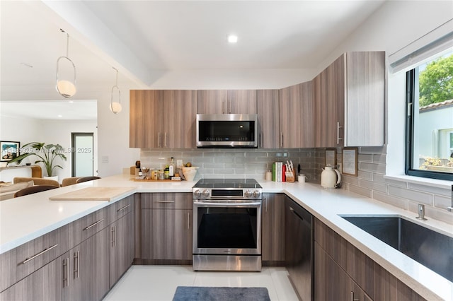 2485 SW 19th Ter, Miami, FL 33145 - kitchen with appliances with stainless steel finishes, modern cabinets, backsplash, and hanging light fixtures