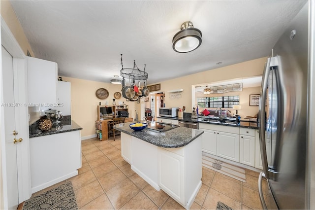 11193 SW 113th Ter, Miami, FL 33176 - kitchen with stainless steel appliances, a kitchen island, white cabinetry, light tile patterned flooring, and dark stone countertops