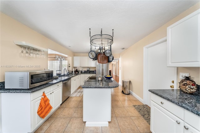 11193 SW 113th Ter, Miami, FL 33176 - kitchen featuring stainless steel appliances, a center island, white cabinetry, dark stone countertops, and light tile patterned flooring