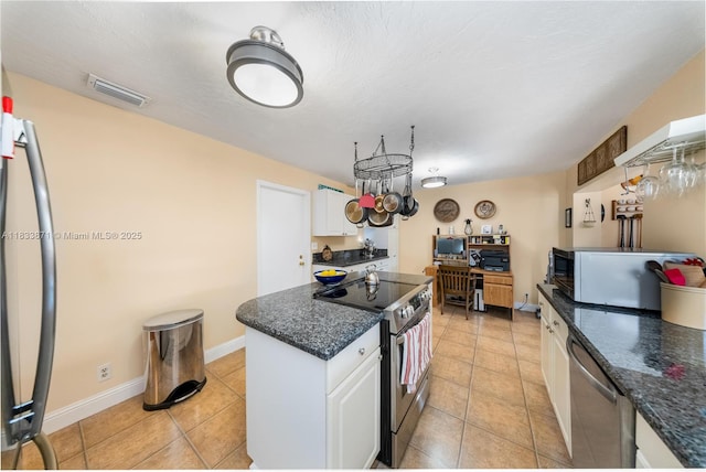 11193 SW 113th Ter, Miami, FL 33176 - kitchen featuring stainless steel appliances, white cabinets, light tile patterned floors, and a kitchen island