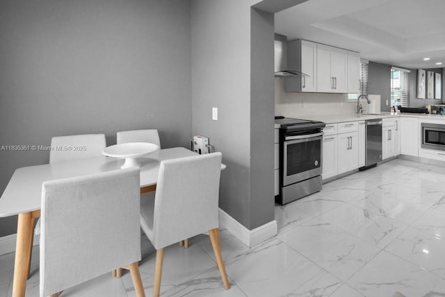 1158 W 41st St Unit 87, Hialeah, FL 33012 - kitchen featuring stainless steel appliances, wall chimney exhaust hood, light marble finish floors, white cabinetry, and light countertops