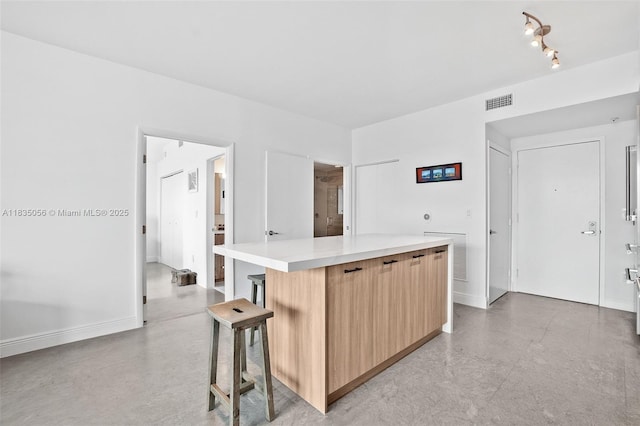 90 SW 3rd St Unit 3810, Miami, FL 33130 - kitchen with modern cabinets, a center island, light brown cabinets, light countertops, and a kitchen breakfast bar