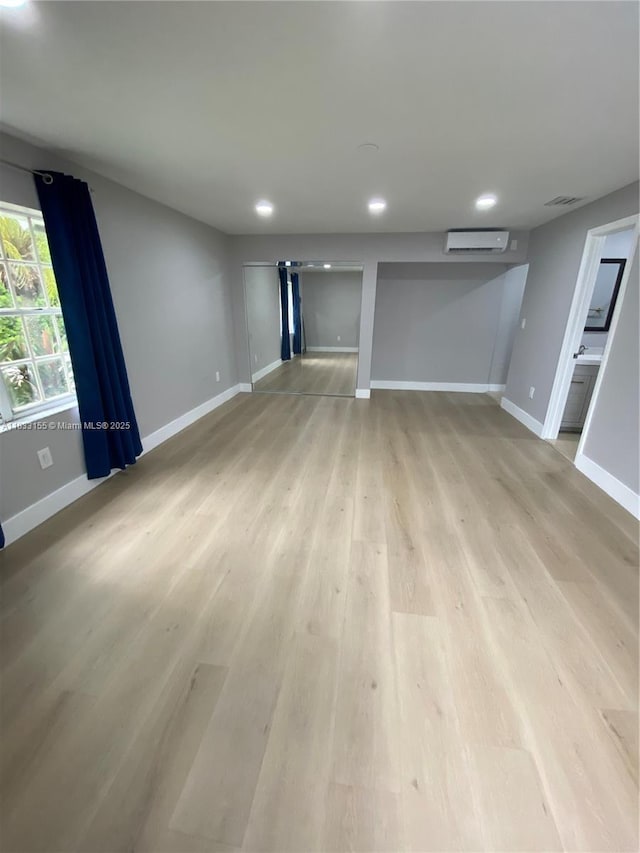 14135 SW 100th Ln, Miami, FL 33186 - unfurnished living room with an AC wall unit, light wood finished floors, and recessed lighting