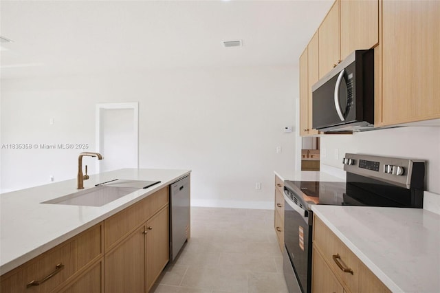 4873/4875 29th St SW, Lehigh Acres, FL 33973 - kitchen featuring appliances with stainless steel finishes, light brown cabinetry, and light stone countertops