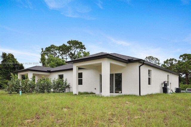 4873/4875 29th St SW, Lehigh Acres, FL 33973 - rear view of property with stucco siding and a lawn
