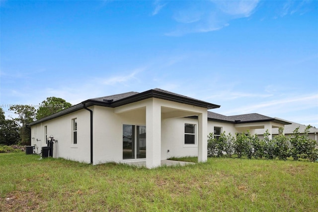 4873/4875 29th St SW, Lehigh Acres, FL 33973 - rear view of house featuring stucco siding and a lawn