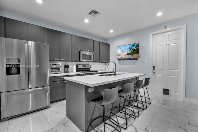 14646 SW 13th St, Pembroke Pines, FL 33027 - kitchen featuring appliances with stainless steel finishes, light marble finish floors, an island with sink, recessed lighting, and a breakfast bar