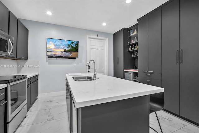 14646 SW 13th St, Pembroke Pines, FL 33027 - kitchen with appliances with stainless steel finishes, light marble finish flooring, a center island with sink, recessed lighting, and dark cabinetry
