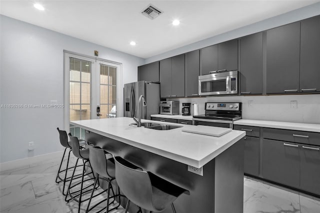 14646 SW 13th St, Pembroke Pines, FL 33027 - kitchen featuring stainless steel appliances, light marble finish floors, an island with sink, a kitchen breakfast bar, and recessed lighting