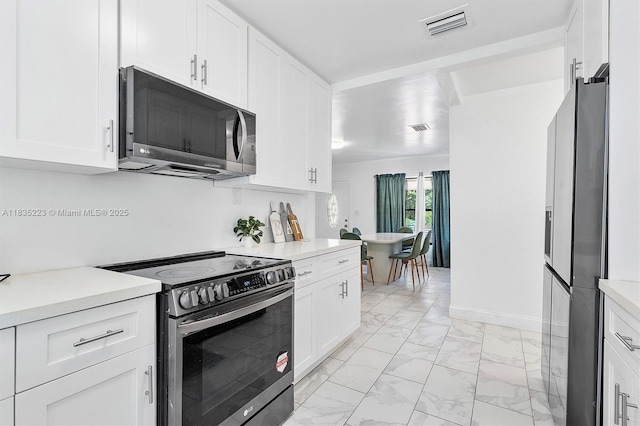 1100 NW 151st St, Miami, FL 33169 - kitchen featuring stainless steel appliances, light countertops, light marble finish floors, and white cabinetry