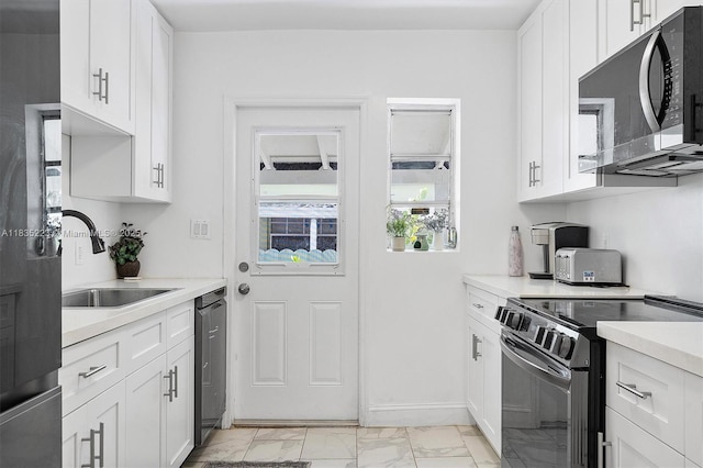1100 NW 151st St, Miami, FL 33169 - kitchen with appliances with stainless steel finishes, light marble finish floors, light countertops, and white cabinets