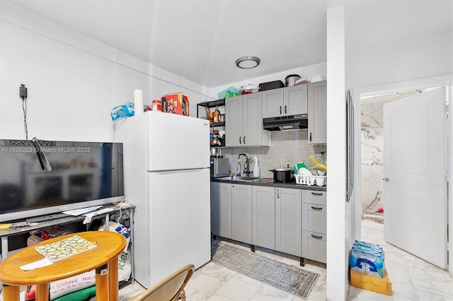 1100 NW 151st St, Miami, FL 33169 - kitchen with under cabinet range hood, freestanding refrigerator, light marble finish floors, dark countertops, and backsplash
