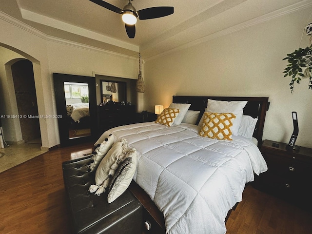 7427 NW 113th Path, Doral, FL 33178 - bedroom with arched walkways, ornamental molding, wood finished floors, a tray ceiling, and a ceiling fan