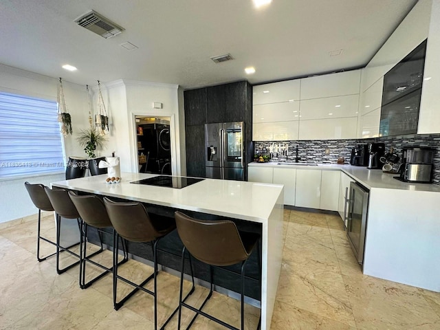 7427 NW 113th Path, Doral, FL 33178 - kitchen featuring fridge with ice dispenser, modern cabinets, black electric stovetop, wine cooler, and a breakfast bar