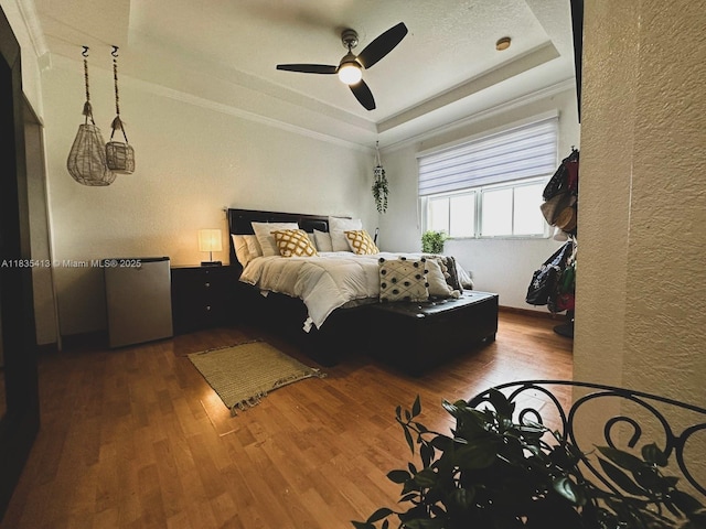 7427 NW 113th Path, Doral, FL 33178 - bedroom featuring wood finished floors, a tray ceiling, a textured wall, ornamental molding, and a ceiling fan